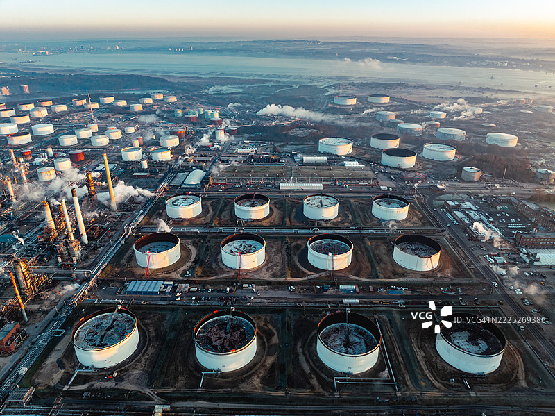 福利石油炼油厂在日落时分冒出烟雾和蒸汽的鸟瞰图图片素材