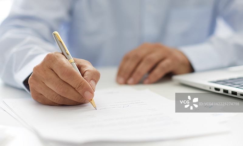 在桌子上填写文件的人图片素材