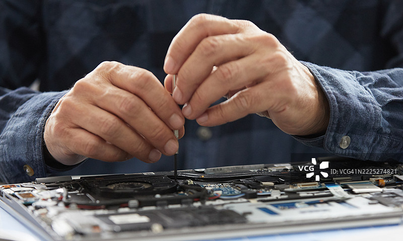 手部特写修理笔记本电脑主板图片素材