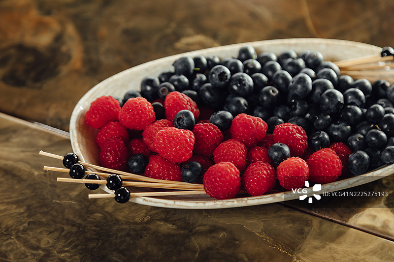 装有覆盆子和蓝莓的盘子图片素材