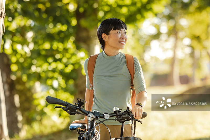 女人在阳光明媚的公园里享受山地自行车骑行图片素材