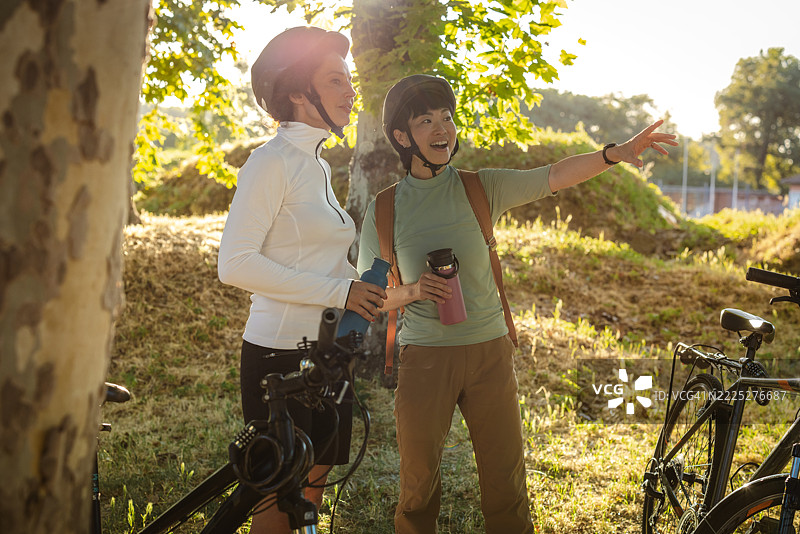 两位戴着头盔的女性在户外骑行冒险中增进感情图片素材