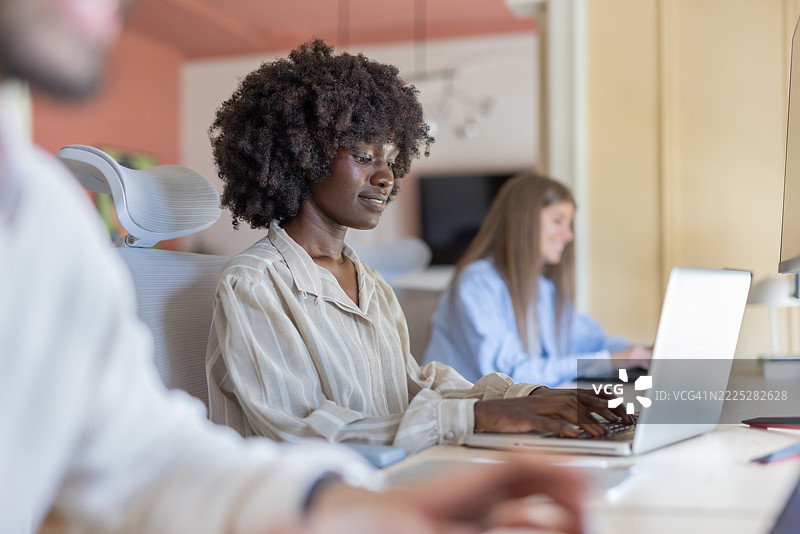 优雅的年轻女士穿着时尚的服装，认真工作。图片素材