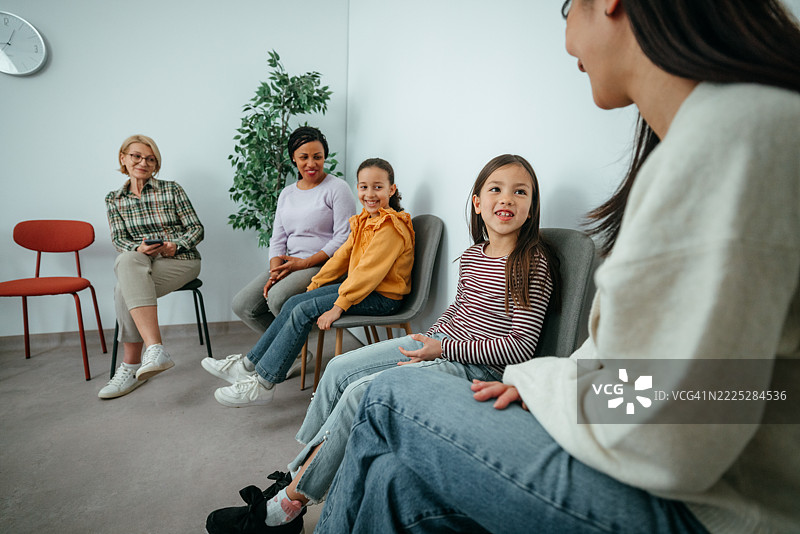 母亲和女儿坐在医院的候诊室里图片素材