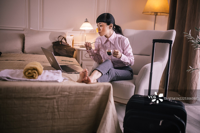 放松的女商人在酒店房间享受咖啡休息时间图片素材