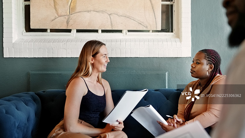 两位不同背景的年轻女学生在咖啡馆一起学习图片素材