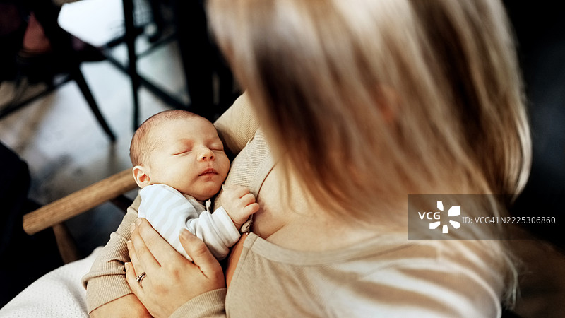 安静的新生儿在慈爱的母亲怀中安然入睡图片素材