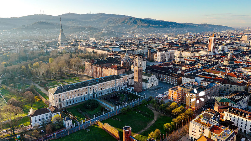 都灵大教堂和安托内利亚塔的鸟瞰图，周围是公园、屋顶和帕拉蒂纳门遗址，历史和建筑地标位于都灵市中心，背靠山丘，展现城市风貌。图片素材