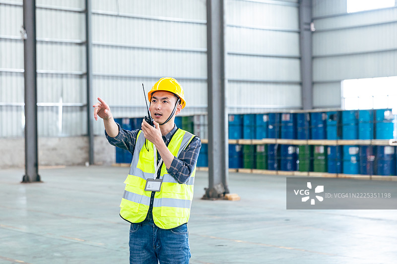 仓库工作人员正在使用对讲机指挥仓库内的工作图片素材