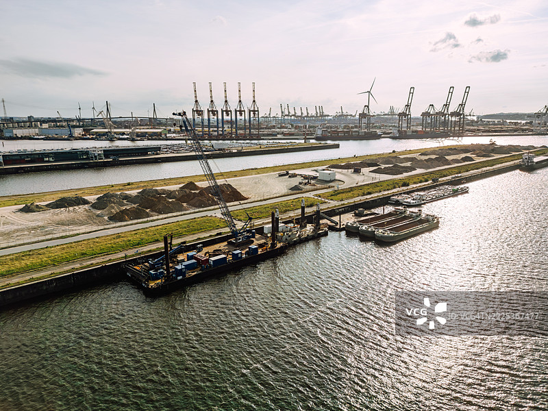 汉堡的工业港口场景，配有起重机、货船和海滨。图片素材