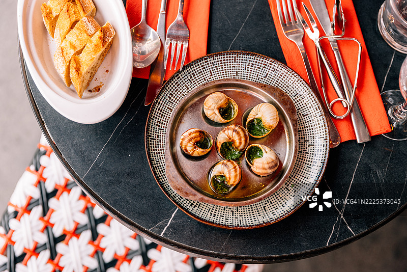 用黄油、香菜和大蒜调味的蜗牛，餐厅内的俯视图，法国巴黎图片素材