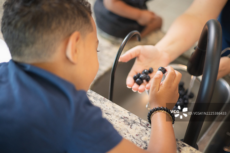 母亲为孩子洗蓝莓作为零食图片素材
