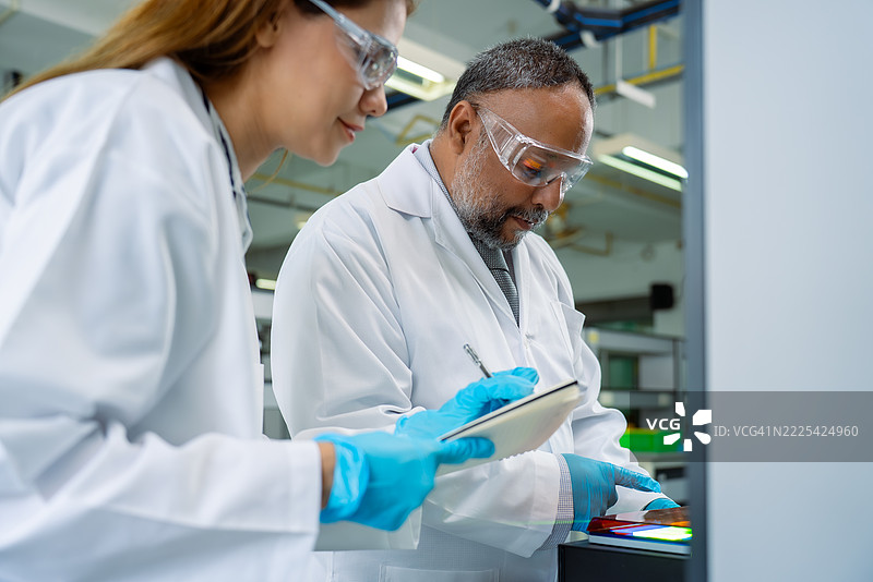 多元化的实验室技术人员在生物科学实验室中审查凝胶电泳结果图片素材