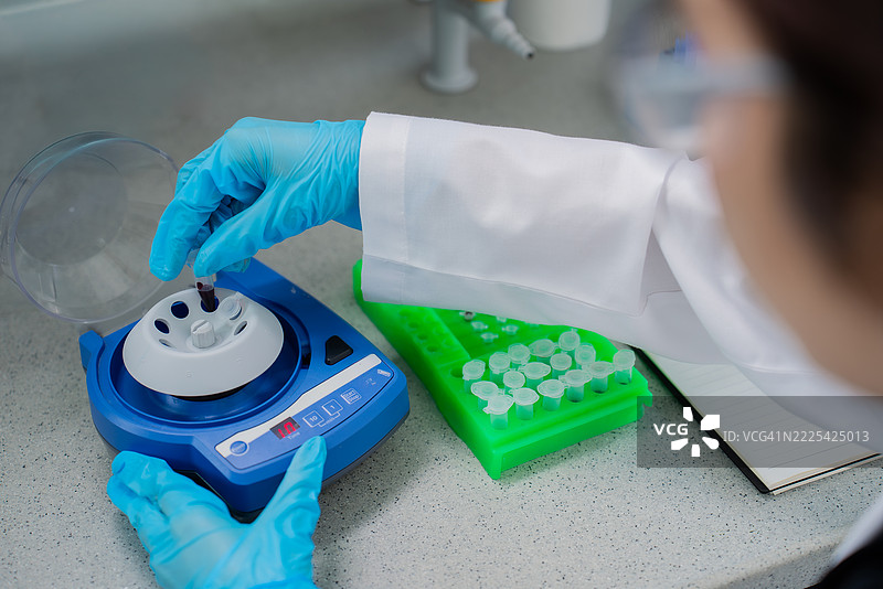 实验室技术人员在生物科学实验室中为样品准备装载微型离心机的特写镜头图片素材