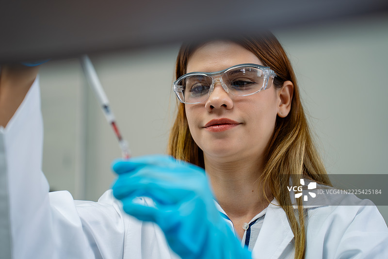 中年女性科学家在实验室使用微量移液器图片素材