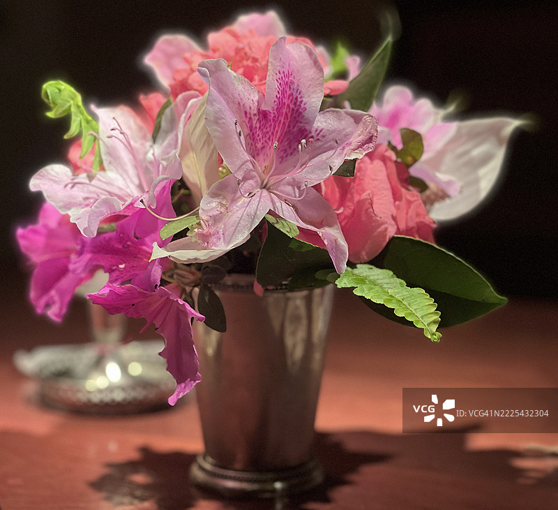 一个银色花瓶，里面插着各种粉色调的花卉组合。图片素材