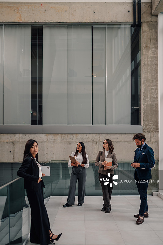 商务人士在现代办公大楼大堂等候图片素材