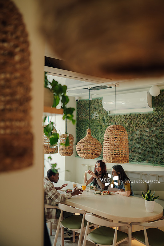 年轻朋友们在现代餐厅里享受午餐图片素材