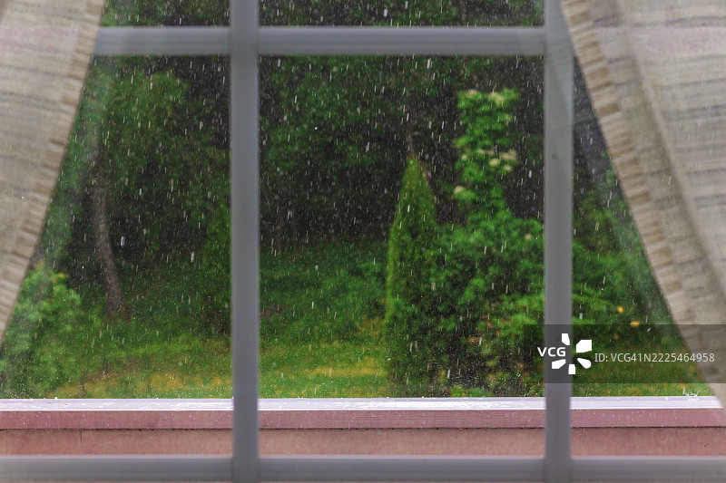 郁郁葱葱的花园，露台，通过窗户看，后院大雨倾盆而下 - 股票照片图片素材
