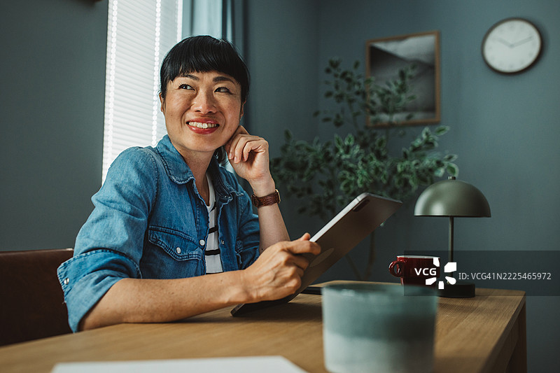 微笑的亚洲女性企业家在办公室使用触控板工作图片素材