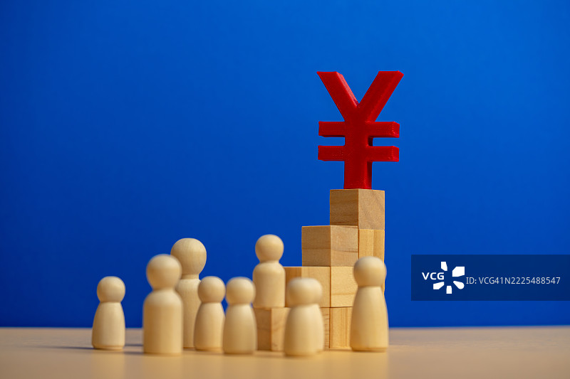 木制人偶在木块上注视着日元符号图片素材