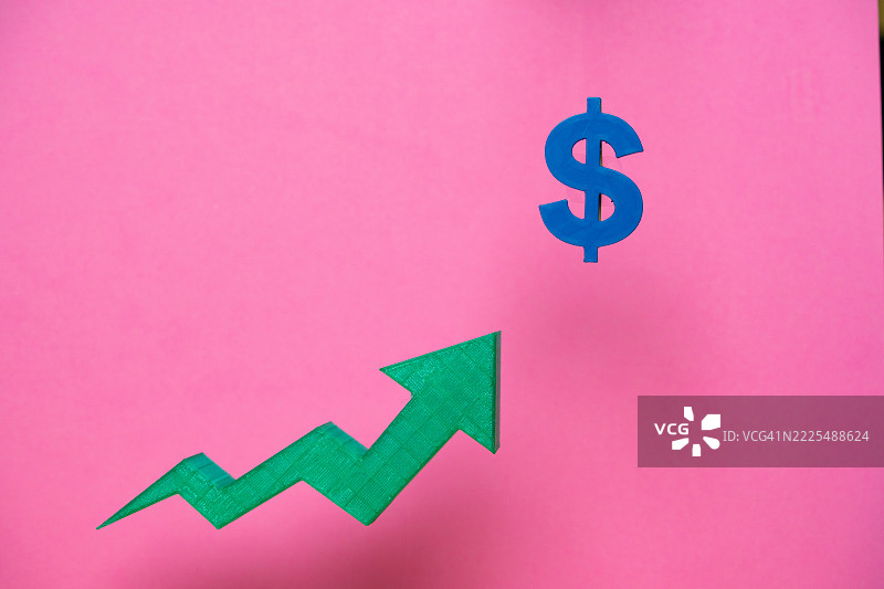 绿色向上的箭头指向粉色背景上的蓝色美元符号图片素材
