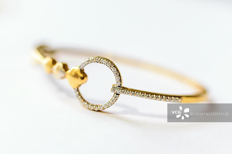 优雅的金手链，镶嵌钻石点缀和心形装饰图片素材