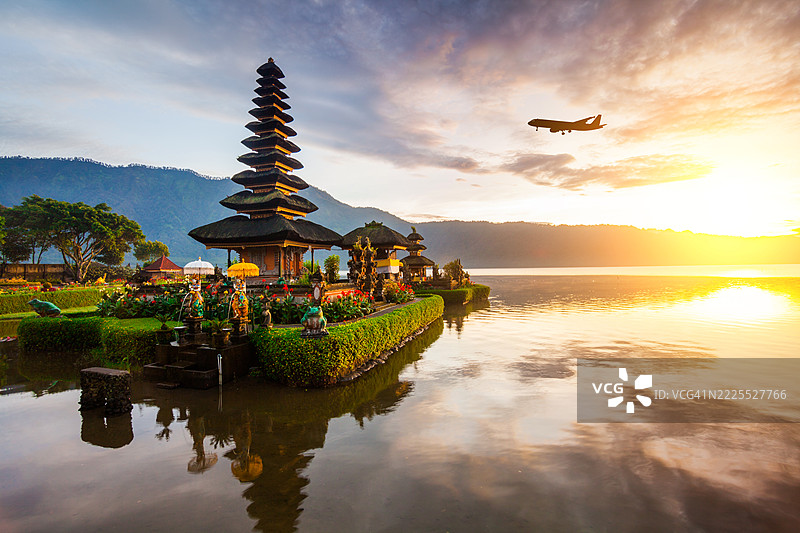 日出时的布拉乌伦达努布拉坦寺和一架飞行的飞机。印尼，巴厘岛图片素材