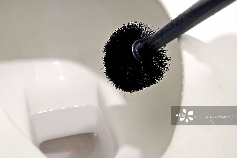 一位家庭主妇正在用刷子清洁厕所图片素材