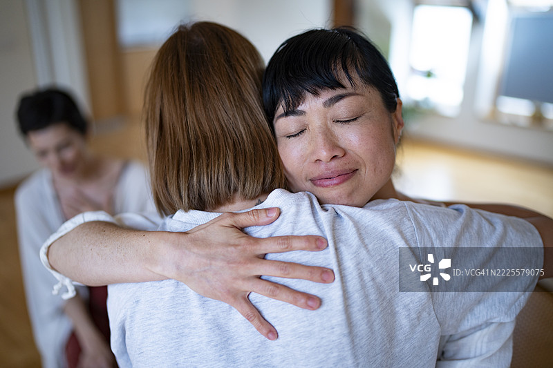 女性在团体治疗会议中相互拥抱和支持图片素材