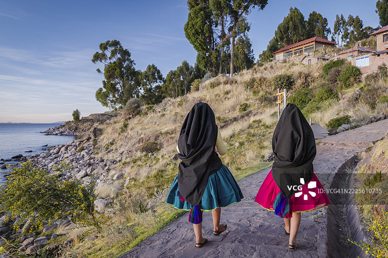 年轻女孩在秘鲁的的的喀喀湖塔基莱岛上手工纺羊毛图片素材