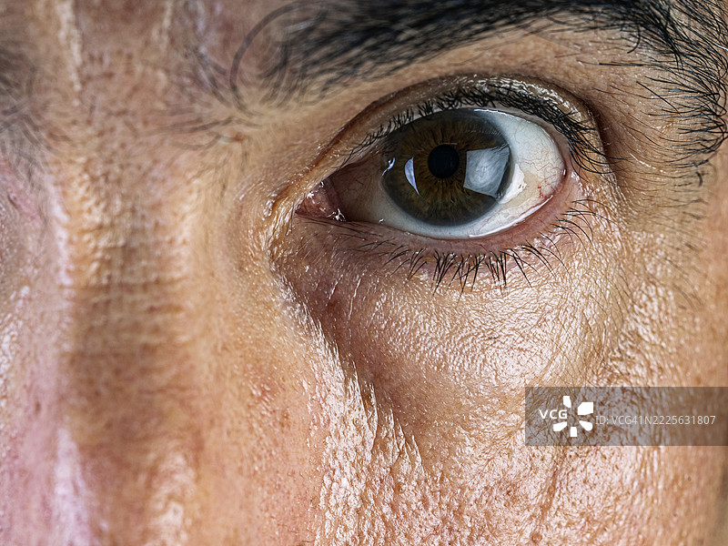 60岁白人男性的睁开眼睛，伴有剃须疙瘩和皱纹。图片素材