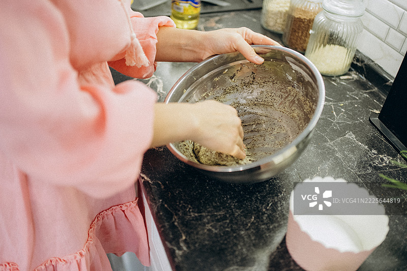 女人在碗中混合材料以烘焙松饼图片素材