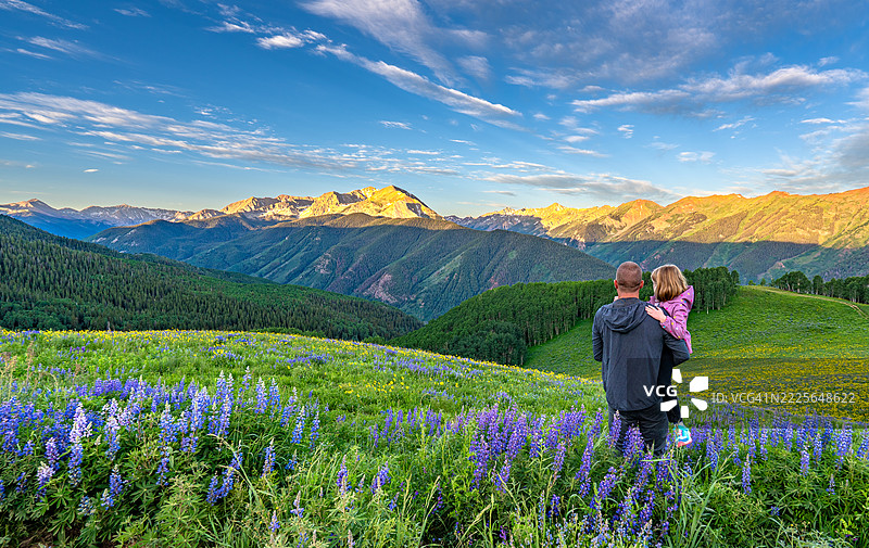 父亲和女儿在美国科罗拉多州中部阿斯彭雪堆村的落基山脉陡坡上，享受夏季野花的清晨时光。图片素材