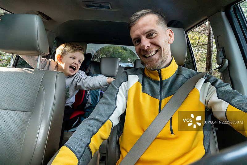 一位中年男子在公路旅行中与儿子一起驾驶的肖像图片素材
