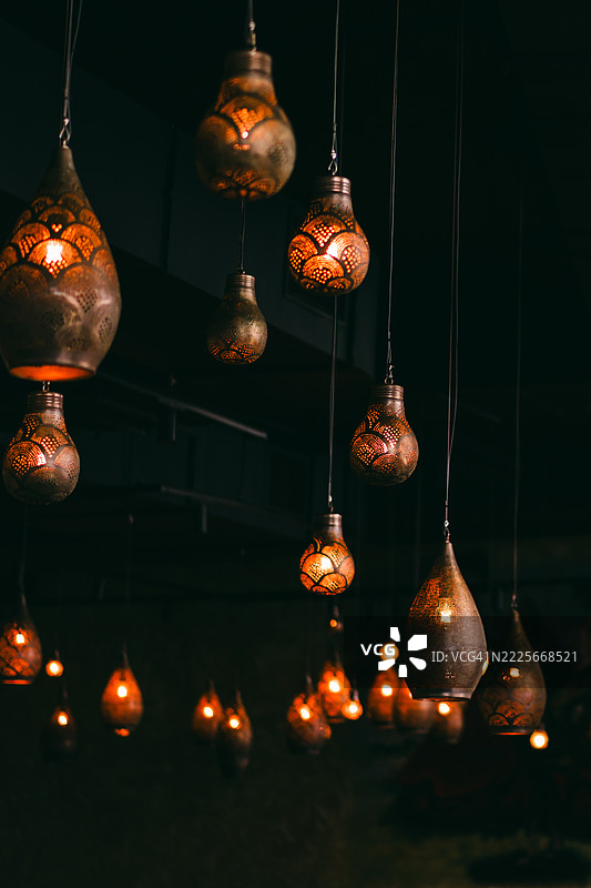 复古悬挂灯笼在温暖色调中照亮舒适的黑暗室内空间图片素材