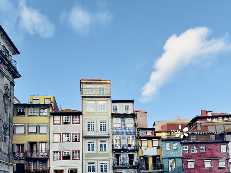 波尔图里贝拉区色彩斑斓的历史建筑，带有瓷砖外立面和红色屋顶，映衬在晴朗的蓝天之下。图片素材