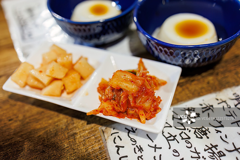特色泡菜和切块萝卜泡菜。特色豆腐（花生豆腐）。菜单展示个性化，例如店主的手写字母等。图片素材
