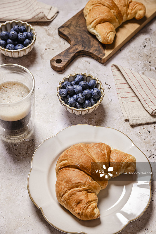 健康的早餐，包括蓝莓、咖啡和可颂面包图片素材