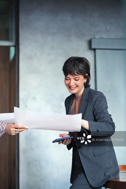 现代办公室中微笑的职业女性与团队合作项目图片素材