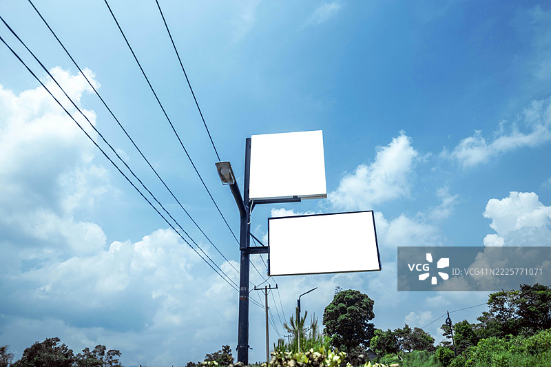 两块空的广告屏幕在多云的蓝天下图片素材