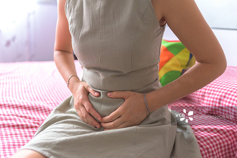 一位面目模糊的女性抱怨腹部疼痛图片素材