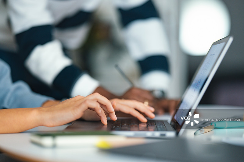 学生们在图书馆里合作使用笔记本电脑进行小组项目图片素材