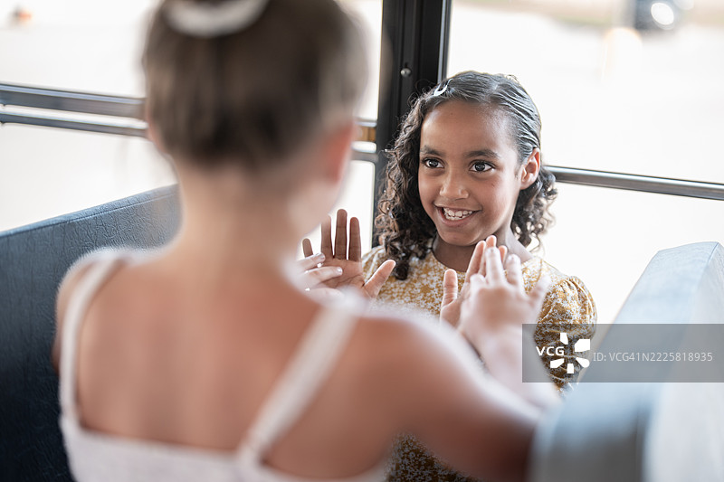 两个小女孩在阳光明媚的日子里玩拍手游戏图片素材