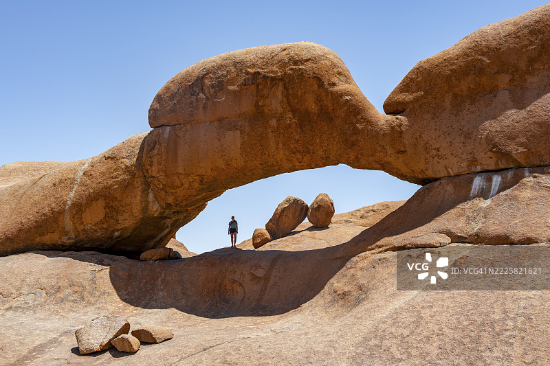 游客在岩石拱门，圆形岩石构造配石拱，蓬托克山，斯皮茨科普大峰，斯皮茨科普，斯皮茨科普自然保护区，纳米比亚图片素材