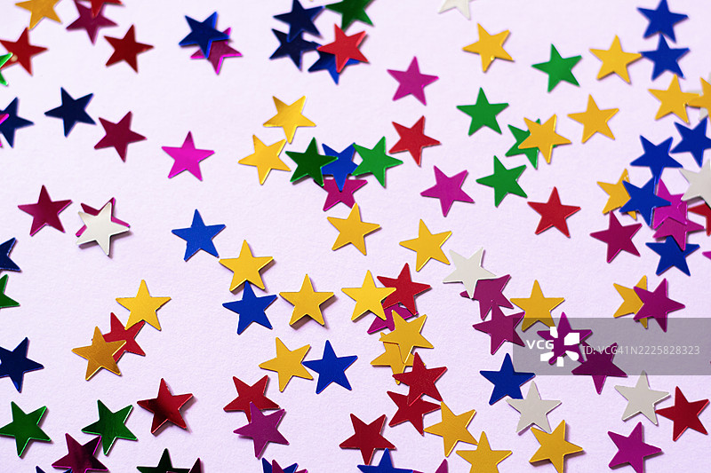 粉色背景上的五彩装饰星星。节日贺卡。图片素材