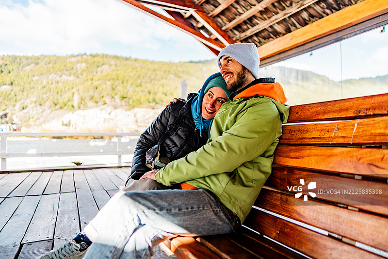 中年夫妇坐在阿根廷巴塔哥尼亚的圣马丁德洛斯安德斯的长椅上交谈图片素材