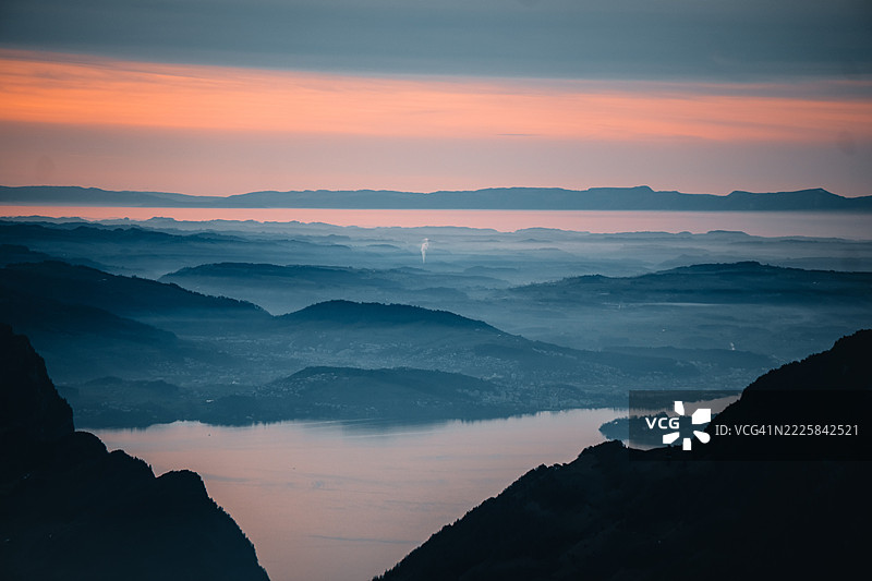 冬季日出时瑞士阿尔卑斯山的雾中湖泊鸟瞰图图片素材