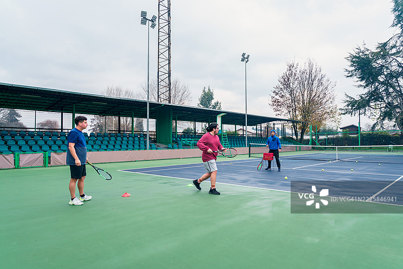 智利网球教练在户外球场训练年轻球员图片素材