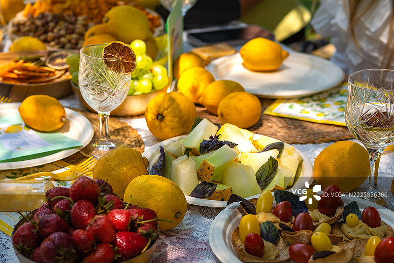 夏季庆祝活动的野餐桌，上面摆满了柠檬和水果。图片素材